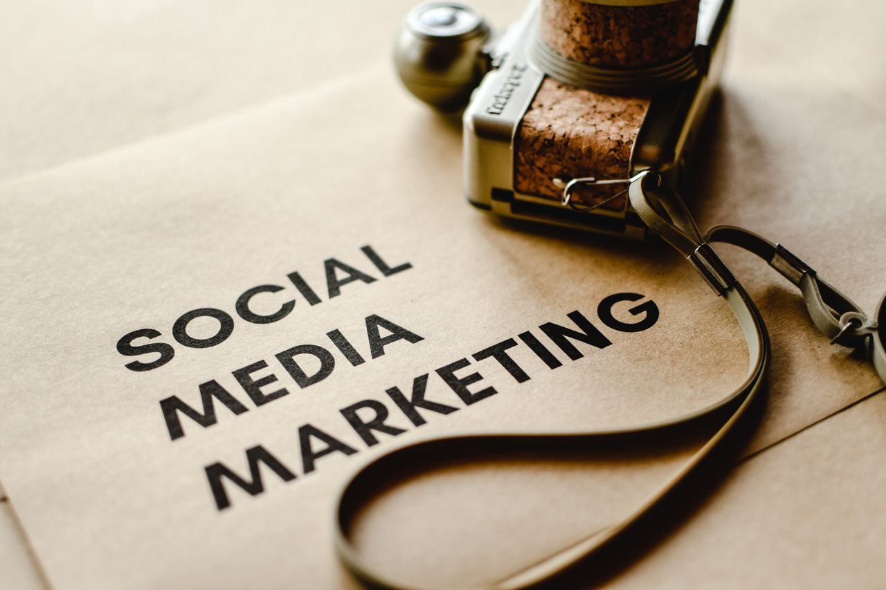Close-up view of a camera resting on brown paper with Social Media Marketing text, highlighting digital marketing themes.